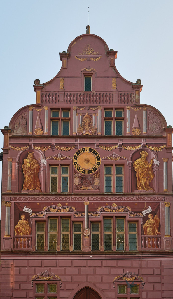 altrosa Seitenfassade des Rathauses von Mulhouse mit goldnen Bildern von Statuen